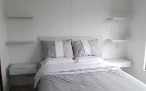 Cama con repisas y mesas de noche flotantes 